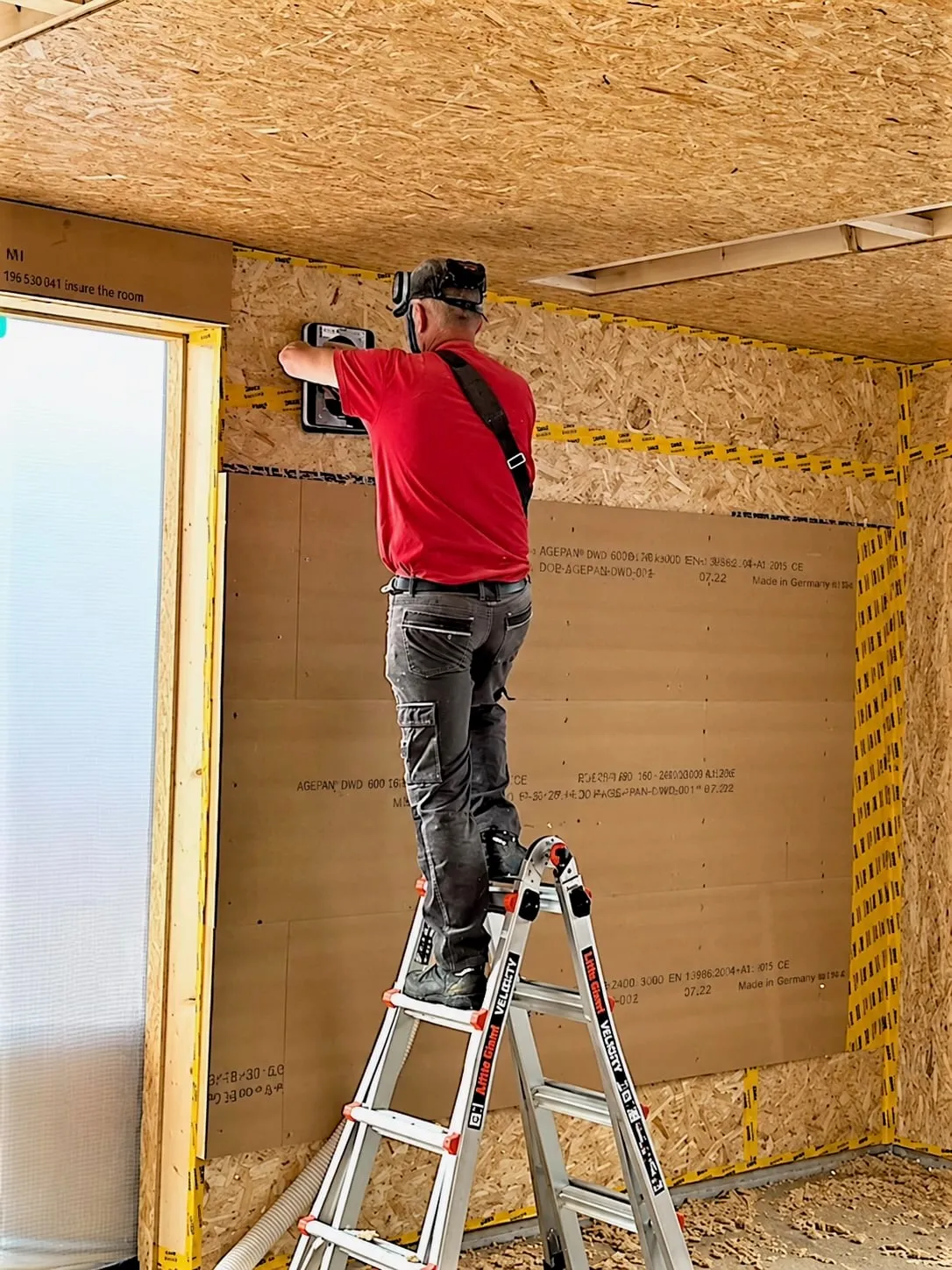 Een medewerker van Thermohouse blaast de natuurlijke isolatie in de wand