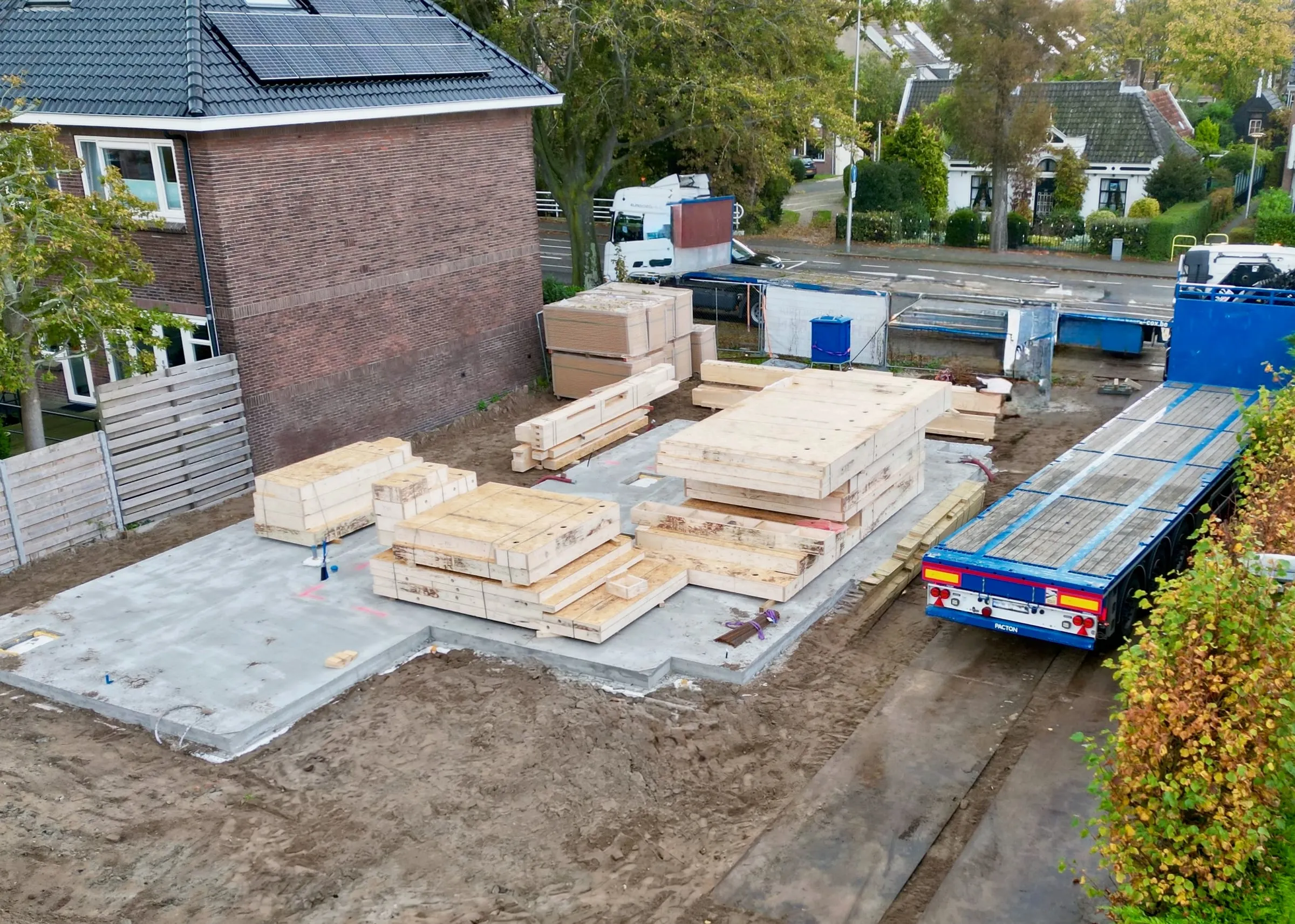 De houten elementen zijn geleverd en liggen klaar op de fundering